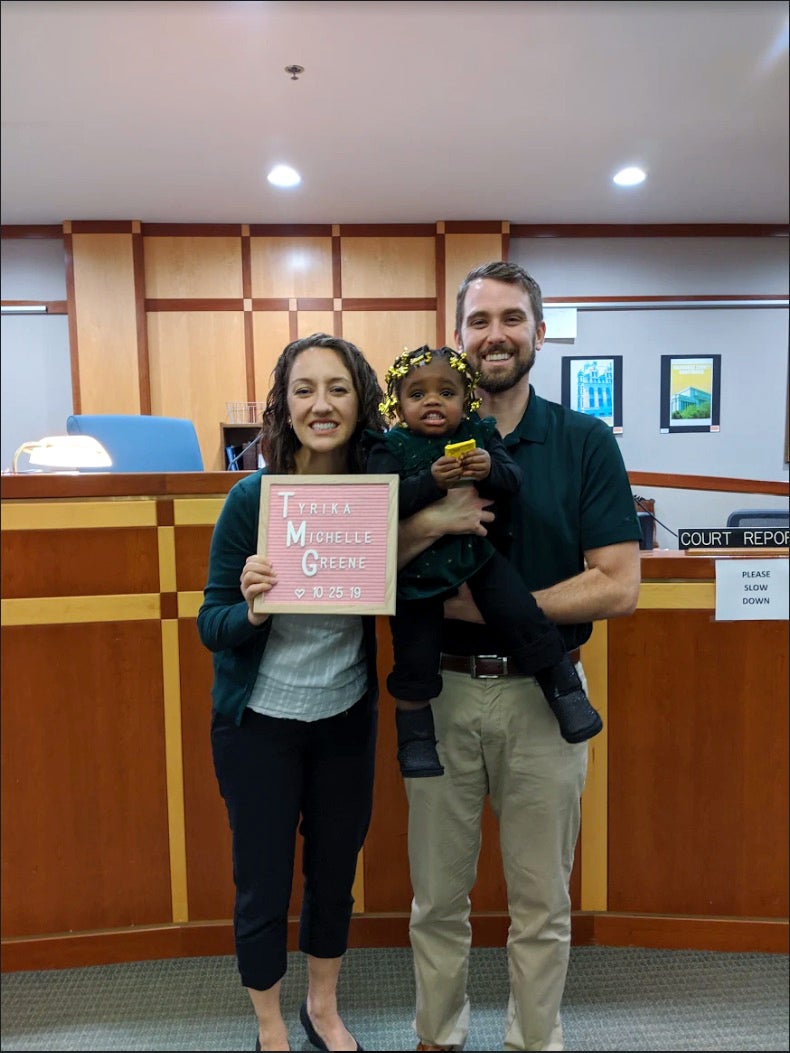 Colleen, Jon, and their adopted daughter in the adoption office